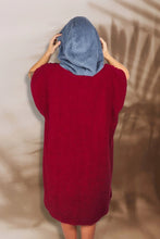 Eine Person, die einen bunten Boho Hippie Surf-Poncho mit aztekischem Muster trägt, steht an einem Strand. Der Poncho reicht bis knapp über die Knie und scheint aus einem dicken, saugfähigen Material zu bestehen. Bohemian Tribal Ethnic Patterned Colorful Beachwear Surfing Hooded Poncho Oversized Unisex Hippie-chic Festival fashion Beach accessory Mexican-inspired Southwestern Geometric Vibrant Multicolored Soft cotton Beach towel Quick-drying surfumkleide