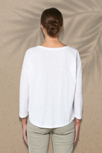 A white long-sleeved shirt for women made from eco-friendly organic cotton. The shirt has a relaxed fit and a front print with a woman's, crescent and wave design. The fabric has a soft texture and offers the wearer a comfortable wearing experience. The product is environmentally friendly and promotes conscious consumption.