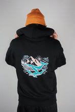 A unisex hoodie, available in black or white, made from eco-friendly materials - a blend of organic cotton and recycled polyester.. On the back of the hoodie is a geometric design of whales and mountains, giving the product a unique and stylish touch gives. The fabric is soft and comfortable, giving the wearer a cozy feeling. Suitable for environmentally conscious consumers, the hoodie promotes sustainable fashion.