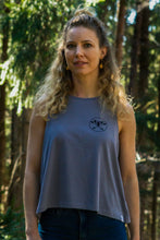 A gray high-neck tank top for women made from eco-friendly materials. The sleeveless top has a loose fit and reaches mid-hip. The fabric has a soft texture and a slight stretch that gives the wearer a comfortable feel. The product is sustainably produced and promotes conscious consumption.